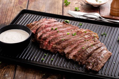 Téléchargez les photos : Bifteck de flanc tranché sur une plaque de cuisson avec sauce au raifort dans un ramequin - en image libre de droit