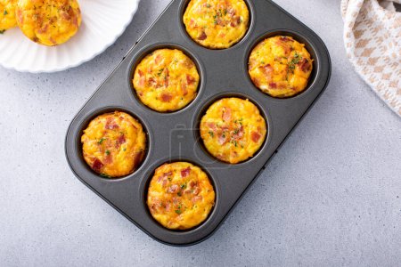 Photo for Breakfast egg muffins or egg bites with potato, bacon and cheddar in a muffin tin - Royalty Free Image