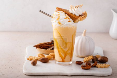 Photo for Pumpkin pie milkshake topped with a slice of pie with caramel sauce and cinnamon - Royalty Free Image