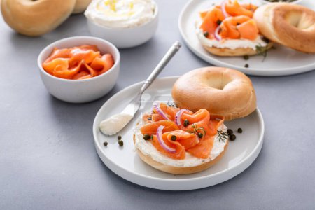 Foto de Panecillo llano con salmón y queso crema con eneldo fresco y alcaparras para el desayuno - Imagen libre de derechos