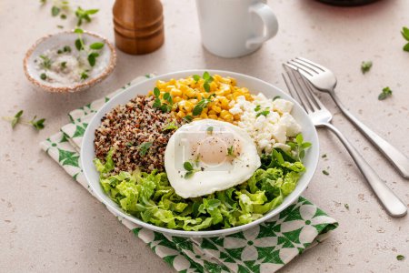 Frühstücksschale mit Quinoa, Kräutermais, Feta-Käse und Spiegelei darüber