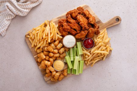 Téléchargez les photos : Bandes de poulet frites et frites avec sauces et céleri, idée de snack fast food - en image libre de droit