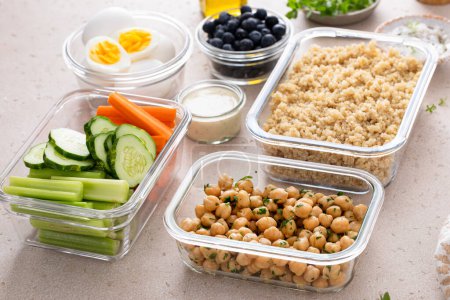 Vegetarische Mittagsmahlzeit in Containern, proteinreiche Mahlzeit mit Quinoa, Kichererbsen, Gemüse und gekochten Eiern