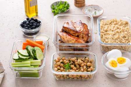 Préparation de repas sains riches en protéines dans des contenants contenant du poulet, du quinoa, des pois chiches aux herbes, des légumes et des ?ufs durs