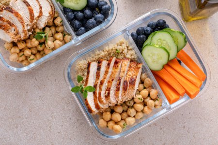 Photo for High protein healthy lunch meal prep in containers with chicken, quinoa, herbed chickpeas, vegetables and boiled eggs - Royalty Free Image