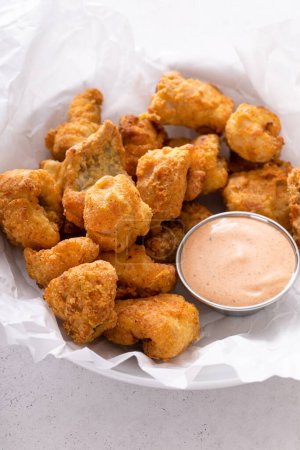 Fried catfish nuggets in a bowl with dipping sauce