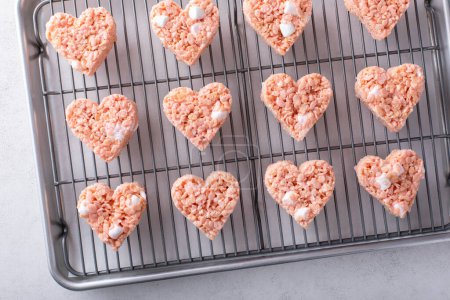 Rosado corazón en forma de arroz krispie golosinas en un estante de enfriamiento, dulce casero para el Día de San Valentín