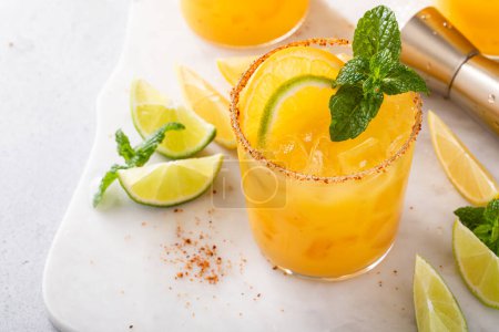 Orange and lime margarita with chili on rim, spicy refreshing tropical margarita cocktail