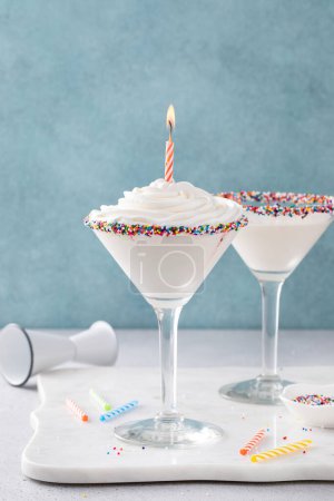Photo for Birthday cake martini cocktail topped with whipped cream and a birthday candle and sprinkles - Royalty Free Image