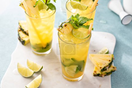 Pineapple mojito with muddled mint and lime served with a sugar cane stick