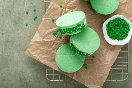 Green sandwich cookies with clover leaf sprinkles, fun dessert idea for Saint Patricks Day
