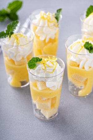 Photo for Lemon meringue parfaits in small cups with pound cake and whipped cream - Royalty Free Image