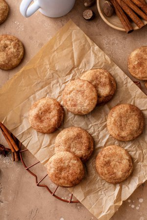 Homemade snickerdoodle cookies covered with cinnamon on parchment paper