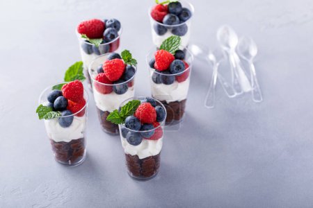 Photo for Chocolate mousse in cups topped with whipped cream and fresh berries - Royalty Free Image