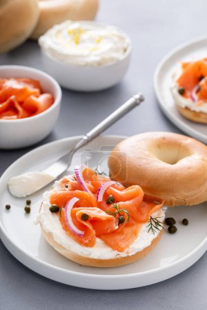 Foto de Bagel con salmón ahumado, queso crema, alcaparras y cebolla roja para el desayuno - Imagen libre de derechos