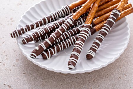 Schoko-Brezelstangen mit dunkler und weißer Schokolade auf einem Teller