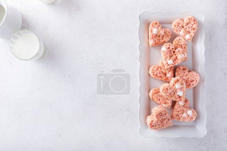 Pink heart shaped rice krispie treats served with milk, homemade sweet treat for Valentines Day