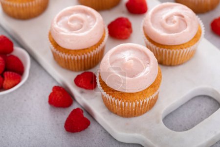 Téléchargez les photos : Cupcakes à la vanille framboise avec glaçage aux framboises tourbillonné - en image libre de droit