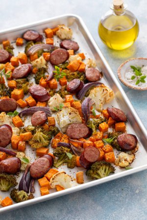 Sheet pan dinner with sausage and vegetables roasted and ready to eat with broccoli and cauliflower