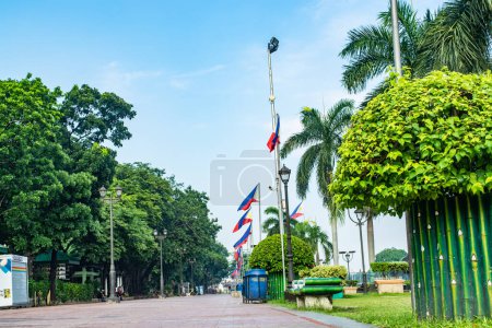 Photo for Rizal Park, Manila, Philippines July 2, 2014: A pathway with a row of Philippine flags and trees at the Rizal Park along Taft Ave., Manila, Philippines - Royalty Free Image