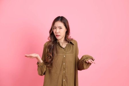 Photo for The young adult Asian woman with brown dressed standing on the pink background. - Royalty Free Image