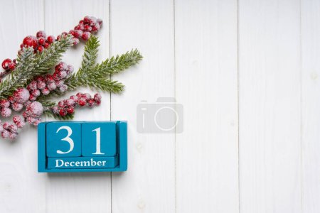 Foto de Rama de árbol de Navidad con decoración y calendario perpetuo azul sobre fondo de madera blanca. Vista superior, plano con espacio de copia, banner, encabezado, fondo de Año Nuevo - Imagen libre de derechos