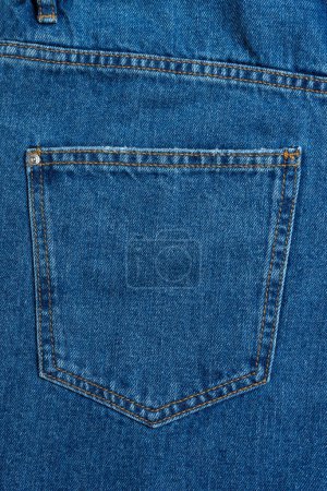 Foto de Back side and pockets of blue jeans pants close-up. Denim background, texture, wallpaper, fashion concept. Design detail, button and seams. - Imagen libre de derechos
