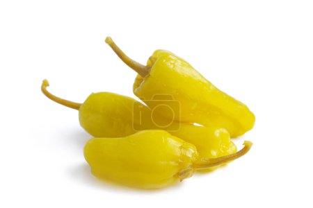 Foto de Three pickled yellow peppers, pepperoncini or friggitelli isolated on white background. Hot pepper marinated, brined. Traditional Italian and greek cuisine, ingredient for salad, pasta, sauce. - Imagen libre de derechos