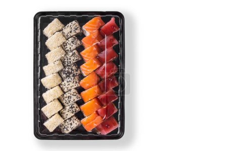 Set de sushi con wasabi, jengibre y salsa de soja servido en caja de plástico para llevar, para llevar. Surtido de sushi japonés con atún, salmón, sésamo aislado sobre fondo blanco. Vista superior, plano