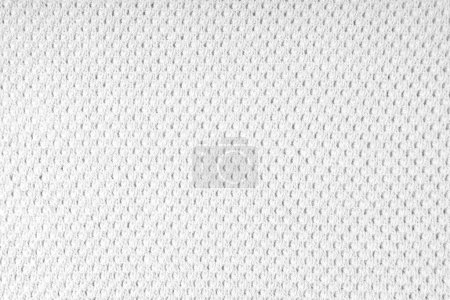 Close up background of knitted wool fabric with dots pattern. White color wool knitwear texture. Openwork abstract knitted jersey. Fabric abstract backdrop