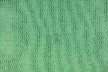 Green knitted woolen jersey fabric, sweater, pullover texture background. Fabric abstract backdrop, cloth wallpaper