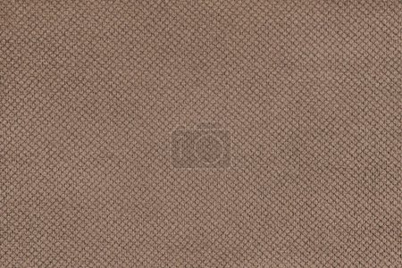 Plain brown velor upholstery fabric, jacquard with fine diamond texture background. Close up, macro cloth textile surface. Wallpaper, backdrop with copy space