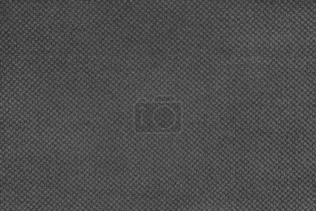 Plain black velor upholstery fabric, jacquard with fine diamond texture background. Close up, macro cloth textile surface. Wallpaper, backdrop with copy space