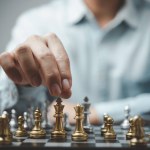 Strategic planning and goals success business idea. Businessman looking at chess at the board.