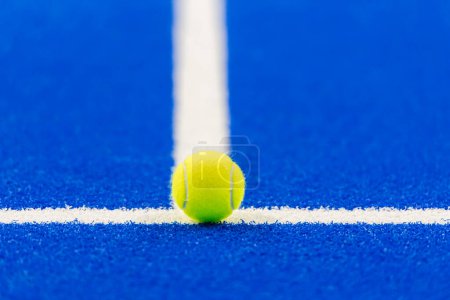 Paddeltennis und Tennisball mit weißen Linien auf blauem Platz. Horizontales Sportplakat, Grußkarten, Kopfzeilen, Website