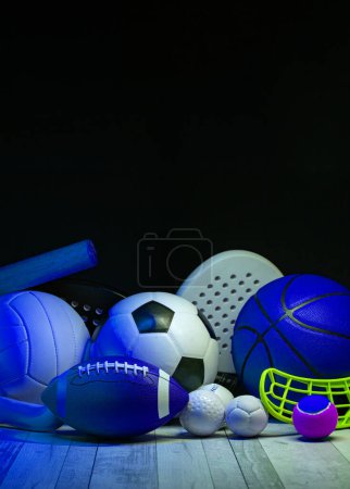 Sportgeräte, Schläger und Bälle auf Hartholzfußboden mit Neonlicht-Hintergrund. Poster für vertikale Bildung und Sport, Grußkarten, Kopfzeilen, Websit