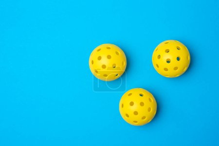 Gelbe Pickleball-Kugeln auf blauem Hintergrund. Horizontales Bildungs- und Sportplakat, Grußkarten, Kopfzeilen, Websit