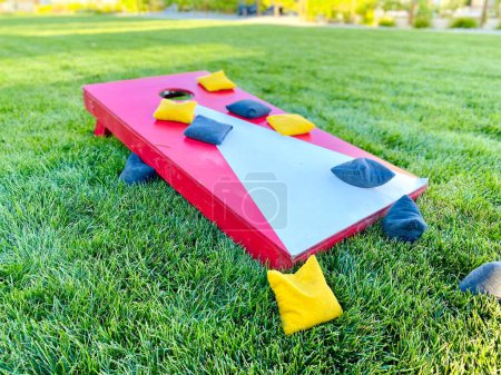 Téléchargez les photos : Cornhole rouge jeu de pelouse loisirs avec des sacs de haricots sur l'herbe en été - en image libre de droit