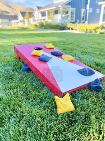 Téléchargez les photos : Cornhole rouge jeu de pelouse loisirs avec des sacs de haricots sur l'herbe en été - en image libre de droit