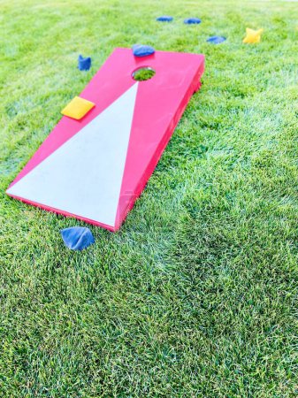 Cornhole rouge jeu de pelouse loisirs avec des sacs de haricots sur l'herbe en été