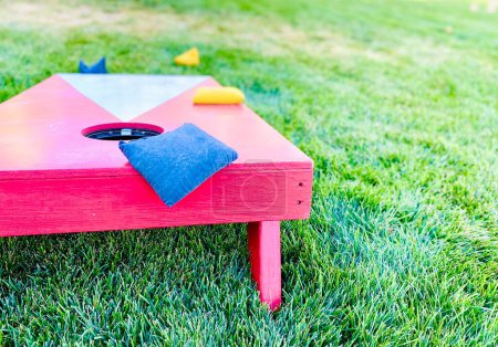 Rotes Kornlochbrett Rasen Spiel Freizeitaktivität mit Bohnensäcken auf Gras im Sommer