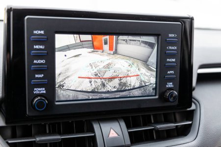 Visualización del sistema multimedia en el salpicadero del coche con una imagen de la cámara de visión trasera para una inversión segura.