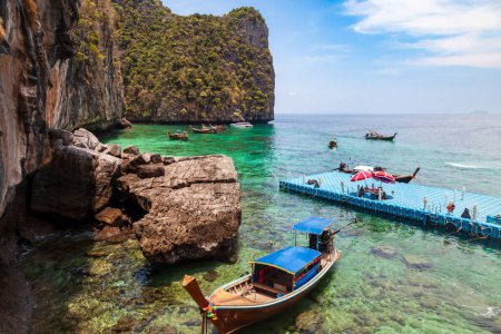 Téléchargez les photos : Quai ou jetée sur l'île phi phi leh à krabi en Thaïlande près de la baie de maya avec des bateaux et des touristes par une chaude journée ensoleillée. Voyages et vacances. - en image libre de droit