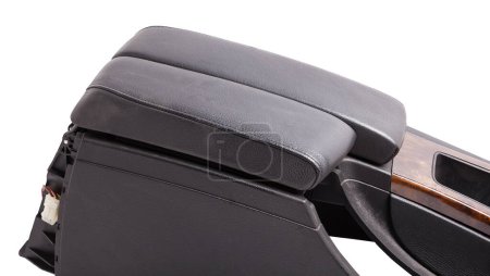 Plastic element of car interior is covered in black leather and wooden - armrest or a glove compartment - spare part with air conditioning holes on a white background. Catalog for site.