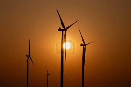 Photo for Silhouettes of wind turbines against the setting sun - Royalty Free Image