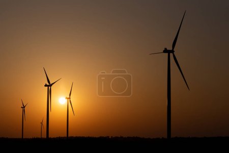 Photo for Silhouettes of wind turbines against the setting sun - Royalty Free Image
