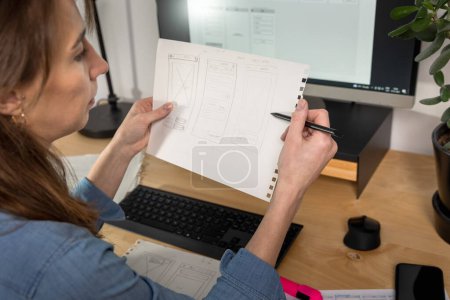 Téléchargez les photos : Sketch of wireframe for website. Women designer working on a mobile application, drawing on paper. - en image libre de droit