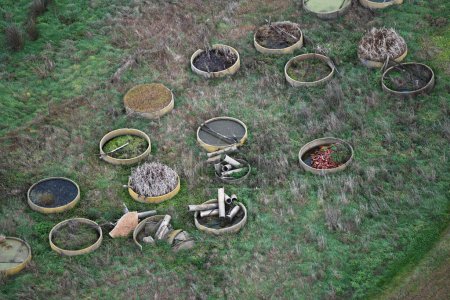 Téléchargez les photos : Les planteurs circulaires de béton restent inutilisés dans une ferme, ce qui représente un potentiel inexploité dans le paysage rural. - en image libre de droit