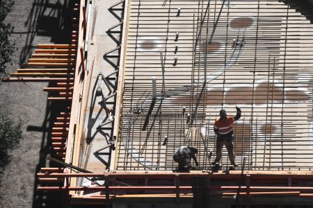 Téléchargez les photos : Vue aérienne des travailleurs de la construction engagés activement sur un chantier de construction, aidant le projet à aller de l'avant. - en image libre de droit