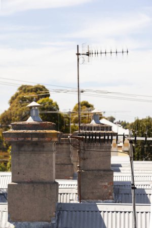 Téléchargez les photos : Vieilles cheminées sur les toits, ajoutant une touche de charme classique aux conceptions architecturales. - en image libre de droit